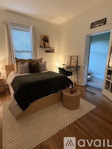 A bedroom with a large bed and a wooden floor.