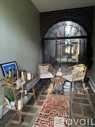 A patio with a table and chairs and a framed picture on a stand.