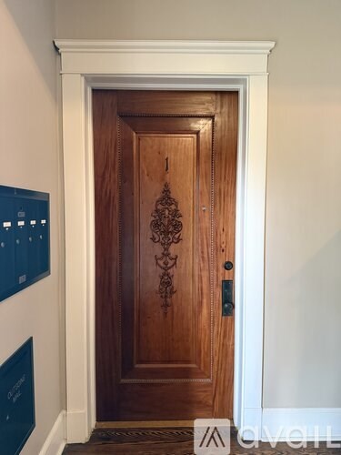 A brown door with a black handle and a decorative design on the front.