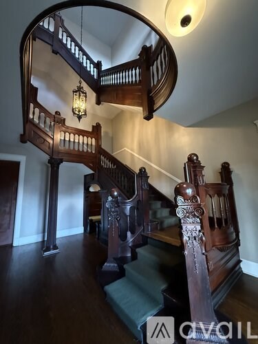 A wooden staircase with a circular balcony on top.