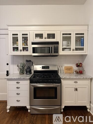 A kitchen with white cabinets and a stainless steel oven.