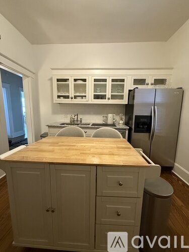 A kitchen with white cabinets and a wooden countertop.