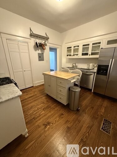 A kitchen with wooden floors and stainless steel appliances.