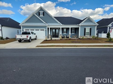 A house with a blue exterior and a white pickup truck parked in front.