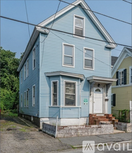 A blue house with a white door and windows.