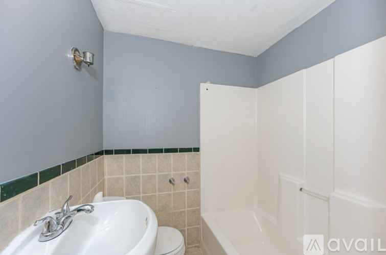 A bathroom with a white sink and a white bathtub.