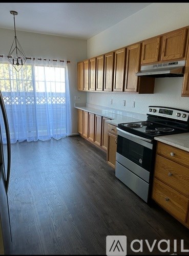 A kitchen with wooden cabinets and a stove top oven.