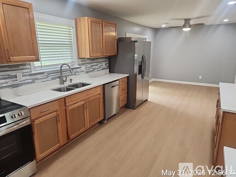 A kitchen with wooden cabinets and a stainless steel refrigerator.