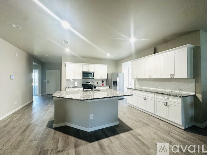 A spacious kitchen with a central island and modern cabinets.
