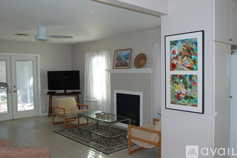 A living room with a fireplace and a painting on the wall.