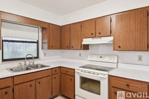 A kitchen with wooden cabinets and white appliances.