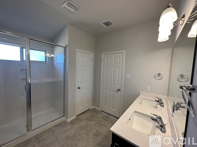 A bathroom with a sink, mirror, and shower.
