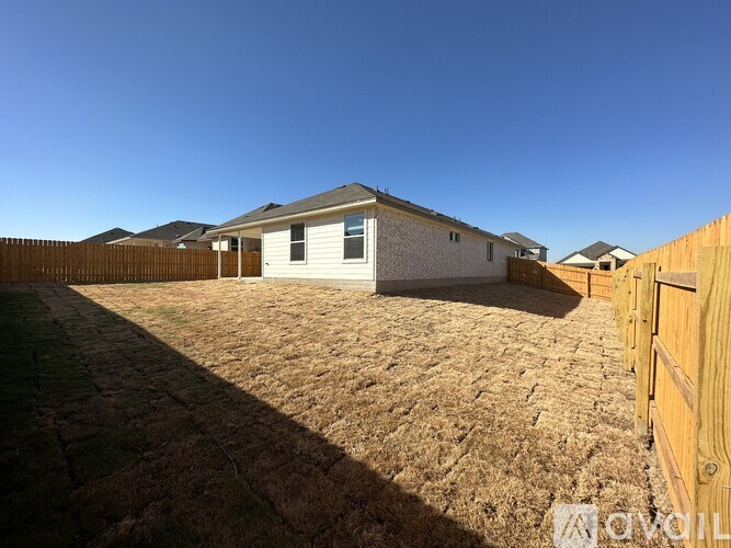 A house with a brown roof and a brown fence.