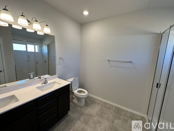 A bathroom with a sink, toilet, and mirror.