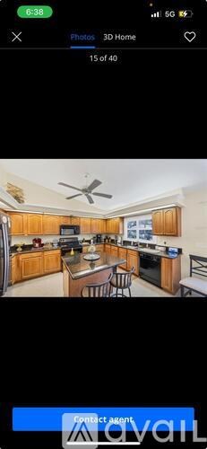 A kitchen with wooden cabinets and a ceiling fan.