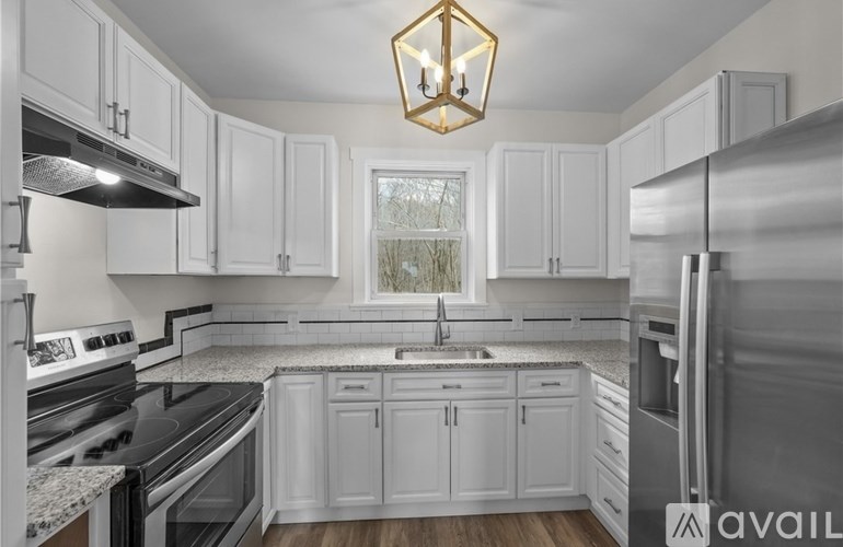 A kitchen with white cabinets and a stainless steel refrigerator.
