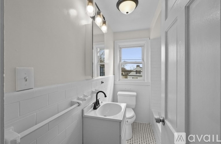 A bathroom with a white tub, sink, and toilet.