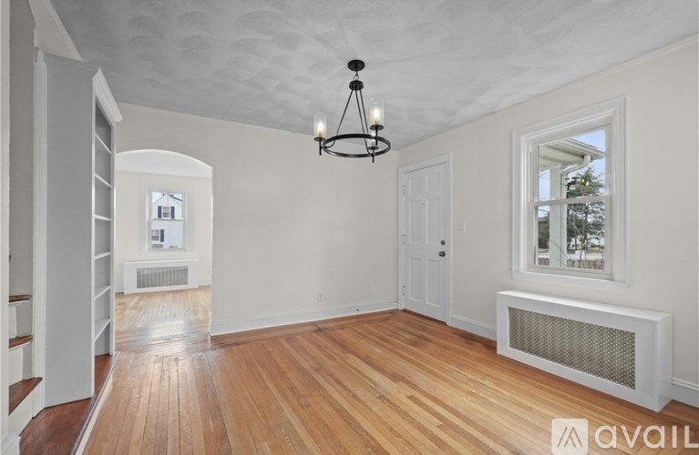 A room with wooden floors and a chandelier.