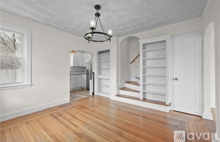 A room with wooden floors and a chandelier.