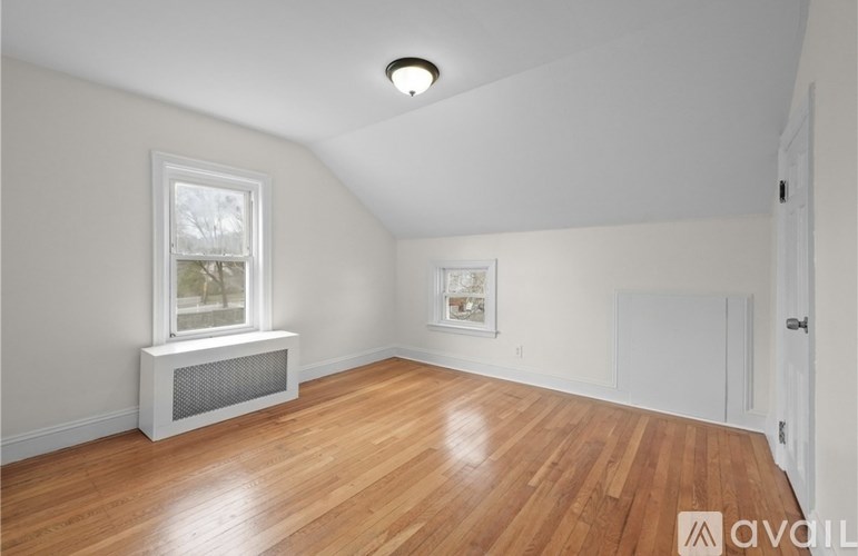 A room with wooden floors and a window with a white frame.