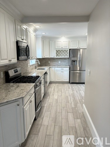 A kitchen with white cabinets and a tile floor.