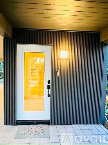 A door with a glass panel and a black handle is on a striped wall.