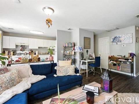 A living room with a blue couch and a coffee table with a purple lantern on it.