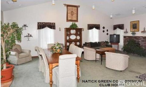 A living room with a couch, chairs, and a television.