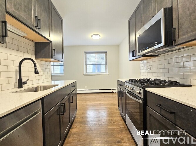 A modern kitchen with dark wood cabinets and stainless steel appliances.