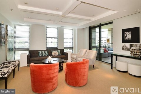 A bright living room with a sofa, two chairs and a coffee table.