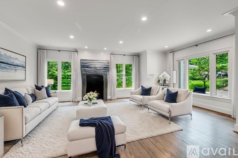 A modern living room with white furniture and a fireplace.