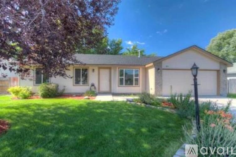A house with a well-maintained lawn and a tree in the front yard.