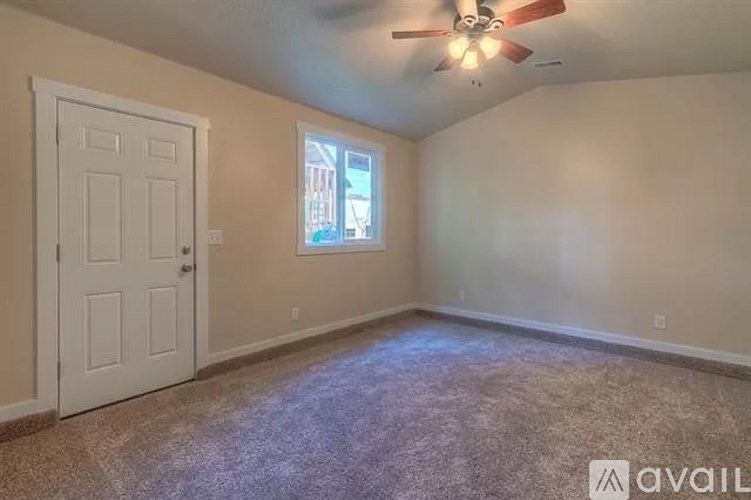 A room with a ceiling fan and a door.