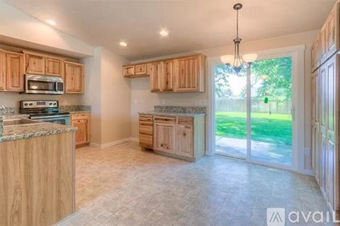 A kitchen with wooden cabinets and a granite countertop.