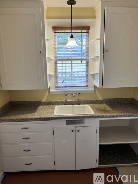 A kitchen with white cabinets and a granite countertop.