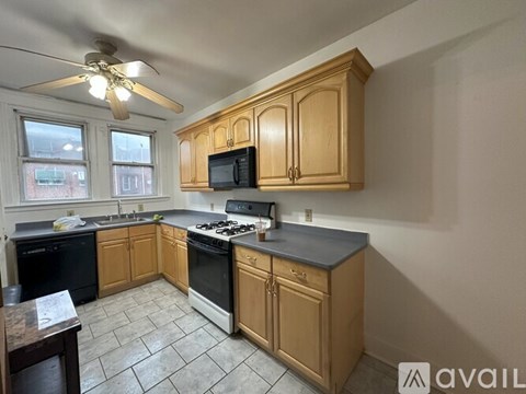 A kitchen with wooden cabinets and black appliances.