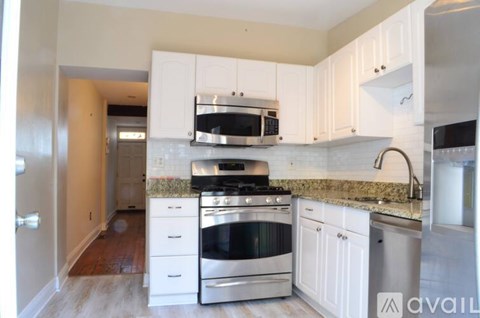 A kitchen with white cabinets and stainless steel appliances.