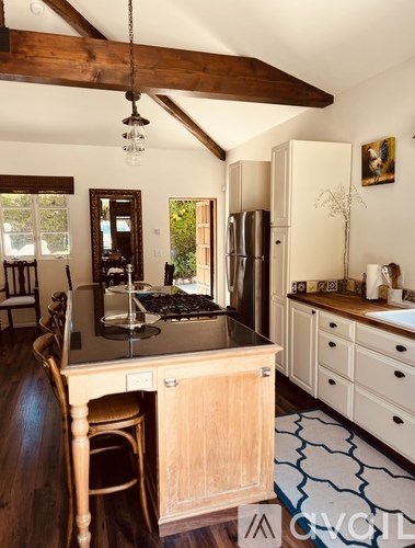 A kitchen with a wooden table and chairs.