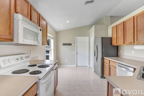 A kitchen with a white stove top oven and a white microwave above it.