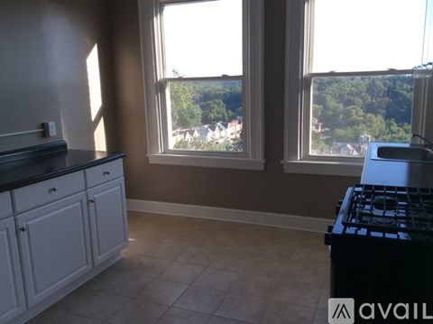 A kitchen with a black stove top oven and a window overlooking a residential area.