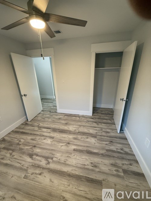 A room with a ceiling fan and a carpeted floor.