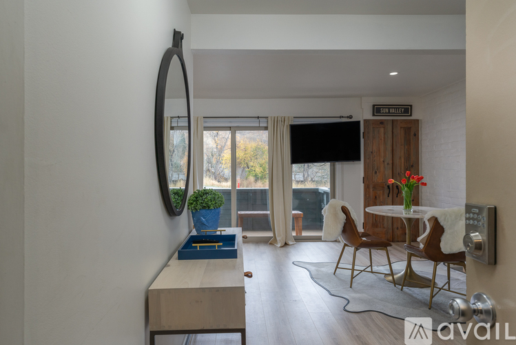 A modern living room with a large mirror and a dining table set up.