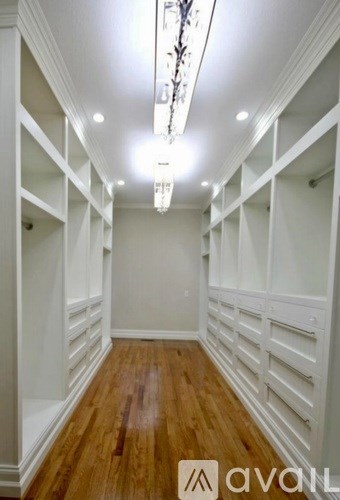 A long hallway with wooden floors and white walls.