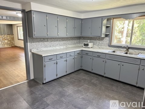 A kitchen with grey cabinets and a countertop with a toaster on it.