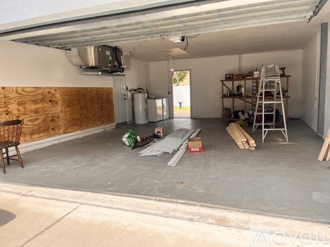 A garage with a ladder and a workbench with tools on it.