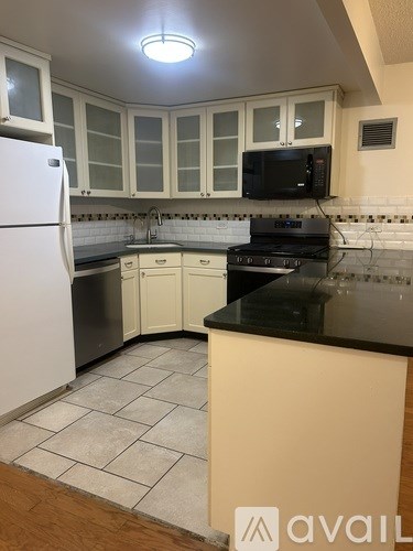 A kitchen with white cabinets and a black stove top.