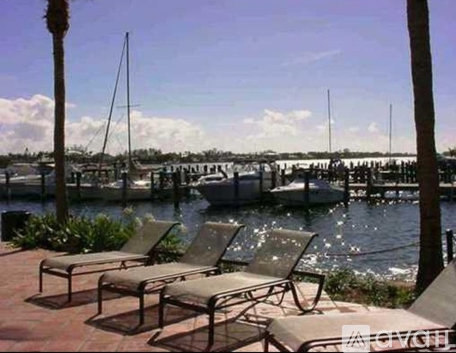 Two chairs are on a patio overlooking a marina.
