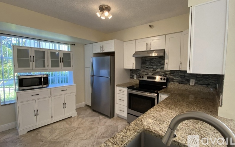 A kitchen with granite countertops and stainless steel appliances.