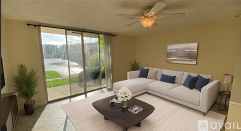 A living room with a white couch and a ceiling fan.