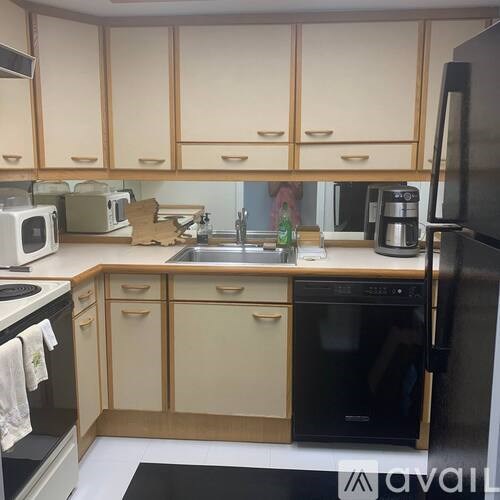 A kitchen with wooden cabinets and black appliances.